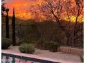 Stunning sunset view from the backyard, featuring a pool and a wall at 42949 N Voyage Trl, Phoenix, AZ 85086