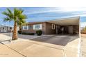Tan single-story home with carport and palm tree in front at 5241 E Lindstrom Ln, Mesa, AZ 85215