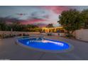 Expansive blue pool with lighting, surrounded by a patio and landscaping at 7760 E Carefree Dr, Carefree, AZ 85377