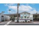 Mobile home with covered carport and desert landscaping at 880 Motherlode Dr # 1099, Apache Junction, AZ 85119
