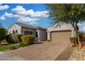 Single-story home with landscaped front yard, driveway, and two-car garage at 9438 W Weeping Willow Rd, Peoria, AZ 85383