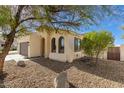 The home's exterior features arched windows, complemented by desert landscaping and a terracotta-colored roof at 10826 W Woodland Ave, Avondale, AZ 85323