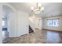 Spacious dining room with tiled floors, chandelier, and staircase at 16649 W Polk St, Goodyear, AZ 85338