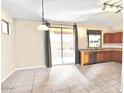 Open floorplan kitchen and dining area with tile floor, light counters, and sliding glass door at 17545 W Canyon Ln, Goodyear, AZ 85338