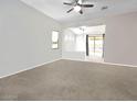 Bright living room featuring neutral tones, a ceiling fan, and an open floorplan to the backyard at 17545 W Canyon Ln, Goodyear, AZ 85338