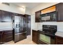 Black appliances and dark wood cabinets in a well-lit kitchen at 3118 N 114Th Dr, Avondale, AZ 85392