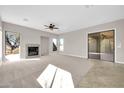 Living room with fireplace, sliding glass doors, and neutral carpet at 38724 N Donovan Ln, Anthem, AZ 85086