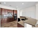 Modern kitchen with dark wood cabinets, granite countertops, and stainless steel appliances at 5026 W Parsons Rd, Phoenix, AZ 85083