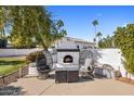 Outdoor patio with fireplace, seating, and desert landscaping at 6542 E Ludlow Dr, Scottsdale, AZ 85254