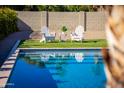 Relaxing poolside view with Adirondack chairs on artificial turf, creating a private backyard retreat at 6759 E Aire Libre Ln, Scottsdale, AZ 85254