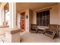 Inviting front porch with cozy seating and a decorative front door at 7709 S 72Nd Dl, Laveen, AZ 85339