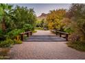Charming wooden bridge over a serene pathway with desert landscaping and mountain views at 5747 E Mockingbird Ln, Paradise Valley, AZ 85253