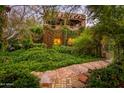 Lush greenery surrounds a charming home exterior, with a stone pathway leading to the entrance at 5747 E Mockingbird Ln, Paradise Valley, AZ 85253