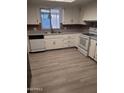 Bright kitchen featuring white cabinets and wood-look vinyl flooring at 120 N Val Vista Dr # 38, Mesa, AZ 85213