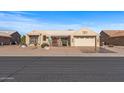 Tan house with terracotta roof, stone accents, and a two-car garage at 14722 W Arzon Way, Sun City West, AZ 85375