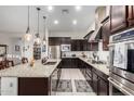 Spacious kitchen featuring granite countertops and dark wood cabinetry at 3222 S 186Th Ln, Goodyear, AZ 85338