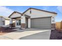 New construction home with a two-car garage and desert landscaping at 3873 S 233Rd Ln, Buckeye, AZ 85326