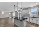 Modern kitchen with white cabinets, island, and stainless steel appliances at 10993 W Pierce St, Avondale, AZ 85323