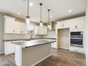 Modern kitchen with white cabinets, gray countertops, and an island at 10993 W Pierce St, Avondale, AZ 85323