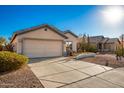 House exterior view, showing a two-car garage and desert landscaping at 14033 W Two Guns Trl, Surprise, AZ 85374