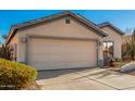 Front view of a house with a beige exterior and a two-car garage at 14033 W Two Guns Trl, Surprise, AZ 85374