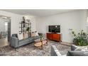 Living room featuring a gray sofa, coffee table, and built-in shelving at 1531 W Colter St # 10, Phoenix, AZ 85015