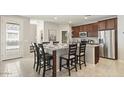 Open concept kitchen with a granite island, seating for six, stainless steel appliances, and dark wood cabinets at 1693 E Dogwood Ln, Gilbert, AZ 85295