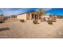 Tan house with a gravel yard and drought-tolerant landscaping at 32014 N Redding St, Wittmann, AZ 85361