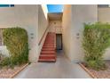 Inviting entryway showcasing a staircase leading to upper-level units, enhanced by lush greenery, and well-maintained building facade at 4201 E Camelback Rd # 25, Phoenix, AZ 85018