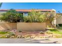 Charming exterior view with terracotta tile roof, mature citrus tree, privacy wall, and rock landscaping for easy maintenance at 4201 E Camelback Rd # 25, Phoenix, AZ 85018