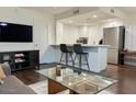 Modern kitchen with breakfast bar, white cabinets, and dark floors at 4760 E Portland St, Phoenix, AZ 85008