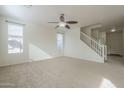 Bright living room with neutral carpeting and a staircase at 4933 E Meadow Mist Ln, San Tan Valley, AZ 85140