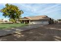 Ranch style home with a large grassy yard and driveway at 6841 N 183Rd Ave, Waddell, AZ 85355