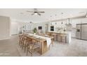 Modern kitchen with island, white cabinetry, and an open dining area at 7818 W Encinas Ln, Phoenix, AZ 85043