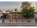 Charming home featuring desert landscaping and a cozy front patio with wood slat privacy screen at 811 W Whitton Ave, Phoenix, AZ 85013