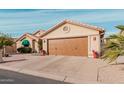 Tan house with brown garage door and desert landscaping at 10606 E Hercules Dr, Sun Lakes, AZ 85248