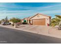 Tan house with brown garage door and desert landscaping at 10606 E Hercules Dr, Sun Lakes, AZ 85248