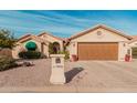 Tan house with brown garage door, green awning, and desert landscaping at 10606 E Hercules Dr, Sun Lakes, AZ 85248