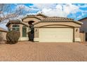 Tan house with a three-car garage and mature trees at 1358 E Jardin Dr, Casa Grande, AZ 85122