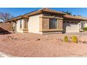 Side view of a charming one-story house with stone accents at 15548 N 156Th Ln, Surprise, AZ 85374