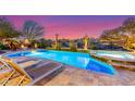 Beautiful pool with a spa, fire pit, desert landscaping, and lounge chairs at 17833 W Verdin Rd, Goodyear, AZ 85338