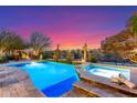 Beautiful pool with a spa, fire pit, and desert views at sunset at 17833 W Verdin Rd, Goodyear, AZ 85338