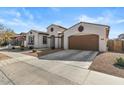 Tan house with a brown garage door and small front yard at 22847 E Sonoqui Blvd, Queen Creek, AZ 85142