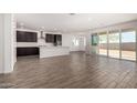 Modern kitchen featuring dark cabinetry, island, and tile floors at 25233 N 131St Dr, Peoria, AZ 85383