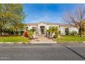 House exterior with stone accents, landscaping, and a large front yard at 3412 E Indigo Cir, Mesa, AZ 85213