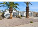 Front view of a white brick house with palm trees and gravel at 4242 E Sacaton St, Phoenix, AZ 85044