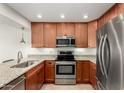 Modern kitchen with wood cabinets, granite counters, and stainless steel appliances at 7910 E Thomas Rd # 118, Scottsdale, AZ 85251