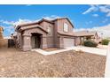 Two-story house with a brown exterior, attached garage, and landscaping at 8802 E University Dr # 66, Mesa, AZ 85207