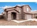 Two-story house with a brown exterior, attached garage, and landscaping at 8802 E University Dr # 66, Mesa, AZ 85207