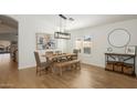 Bright dining room with wood floors, modern lighting, and neutral decor open to living area at 9970 E Monte Cristo Ave, Scottsdale, AZ 85260